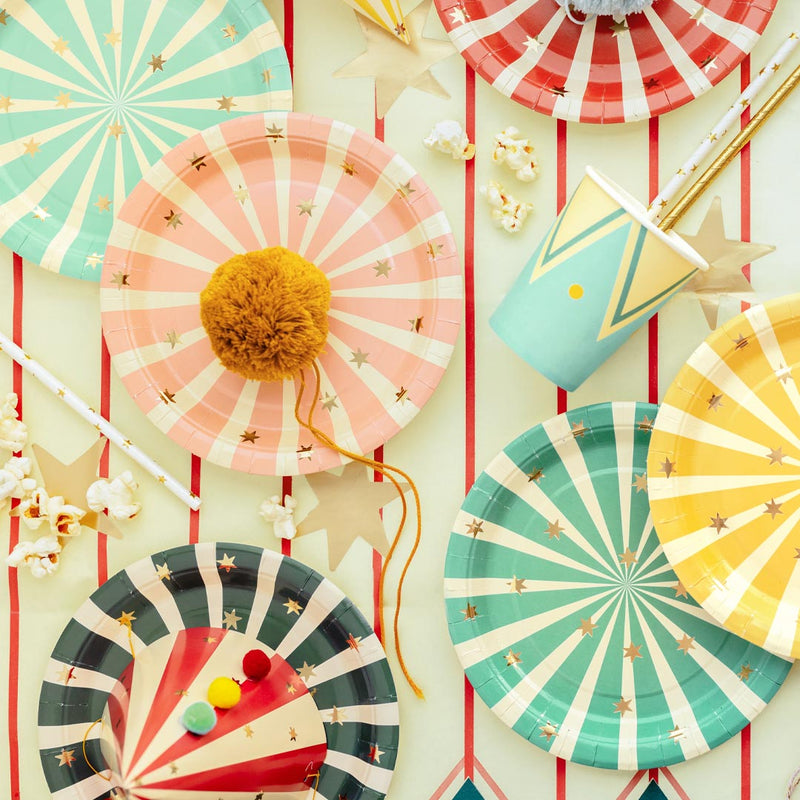 Mesa de cumpleaños infantil temático de circo decorada con platos de papel a rayas y estrellas