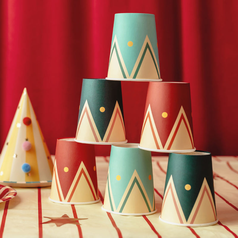 Mesa de fiesta temática de circo decorada con vasos de papel geométricos en colores surtidos