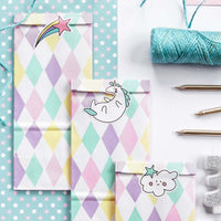 Bolsas de papel unicornio con estampado en rosa, lila, verde y amarillo y pegatinas de estrella fugaz, nube y unicornio. Pack de 6 bolsas.