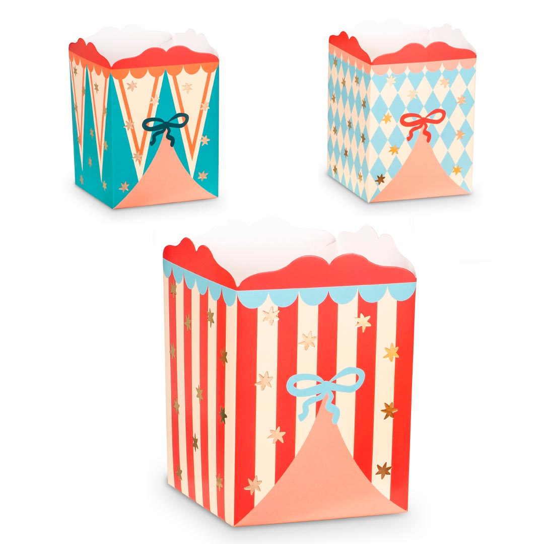 Detalle de caja de papel circo con rayas rojas, lazo azul y estrellas doradas para palomitas