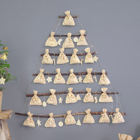 Calendario de Adviento con saquitos de algodón y números de madera en árbol de navidad