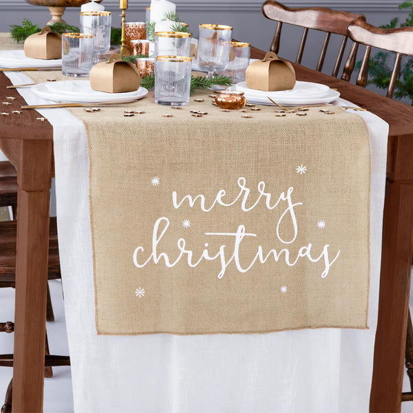 Mesa navideña decorada con camino de yute natural y adornos festivos