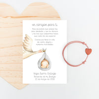 Pulsera con tarjeta corazón para invitados de bautizo con diseño de cigüeña. 