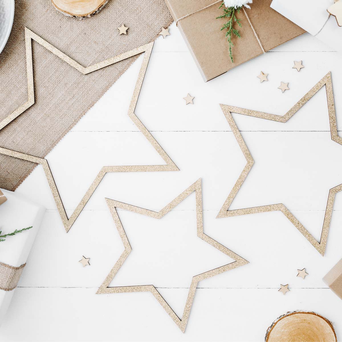 Detalle de set de 3 estrellas de madera dorada con purpurina. Adorno colgante 