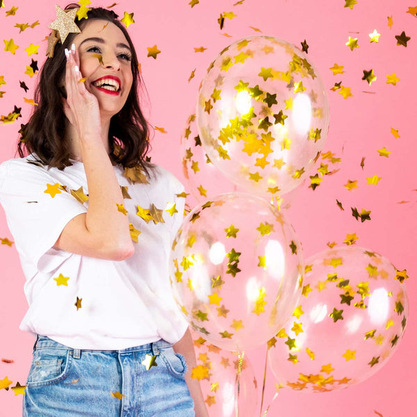 Globo transparente de 30 cm con confeti metálico dorado en forma de estrellas. Pack de 6 unidades.