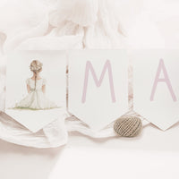 Guirnalda personalizada con el nombre de la Colección Boho Comunión, letras en color lila y banderines con ilustración de niño o niña.