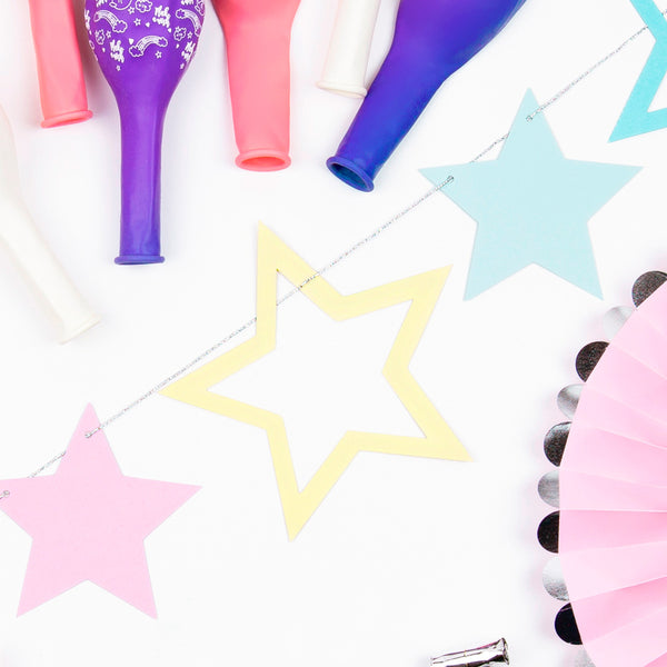 Guirnalda de estrellas en tonos pastel (lila, rosa, azul y amarillo) con cuerda de 2 metros. Ideal para fiestas y cumpleaños.