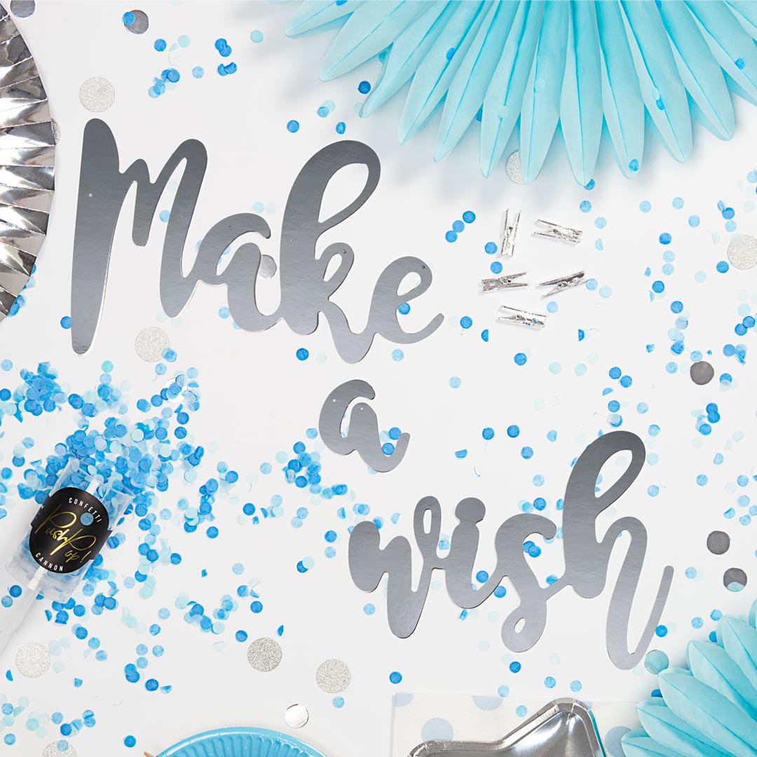 Guirnalda decorativa “Make a Wish” en papel espejo plateado. Incluye cuerda de 2 metros con decoración azul.