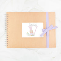 Libro de firmas personalizado para bautizo con diseño y lazo en color lila.