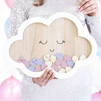 Libro de firmas nube con gotas de colores presentado en una mesa de comunión o bautizo.