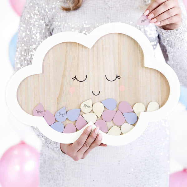 Libro de firmas nube con gotas de colores presentado en una mesa de comunión o bautizo.