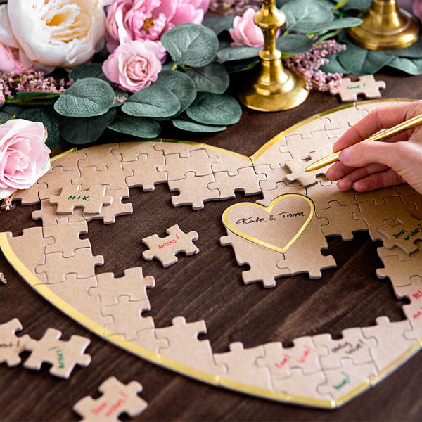 Libro de firmas puzzle en forma de corazón kraft con detalles dorados, 85 piezas en mesa decorada.