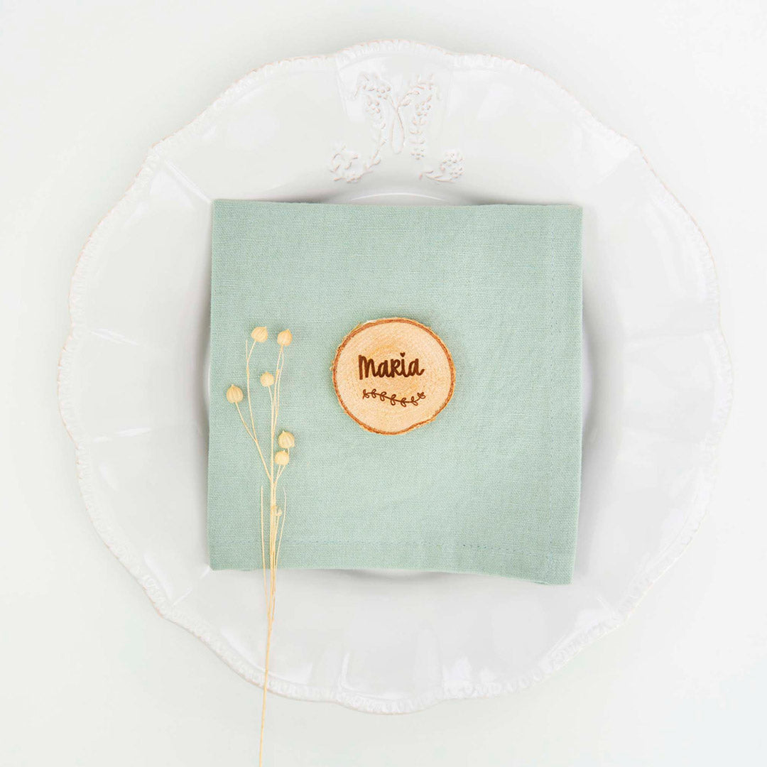 Marcasitios rodajitas de madera grabadas con el nombre de cada invitado en plato