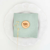 Marcasitios rodajitas de madera grabadas con el nombre de cada invitado en plato