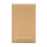 Detalle de sobres kraft con inscripción plateada “Happy Tears”, detalle de boda con pañuelos para lágrimas de felicidad.