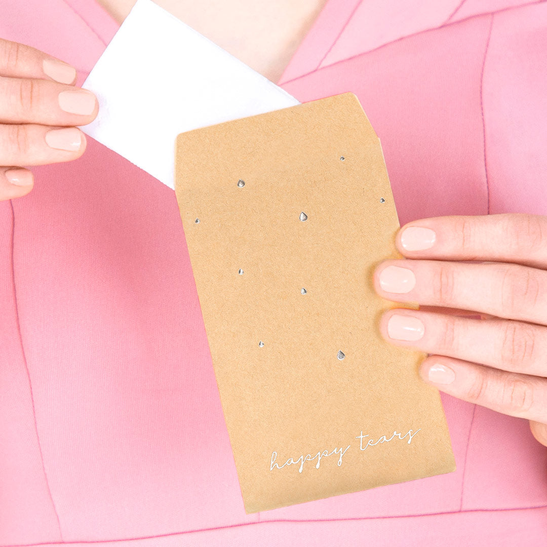 Sobres kraft con inscripción plateada “Happy Tears”, detalle de boda con pañuelos para lágrimas de felicidad.