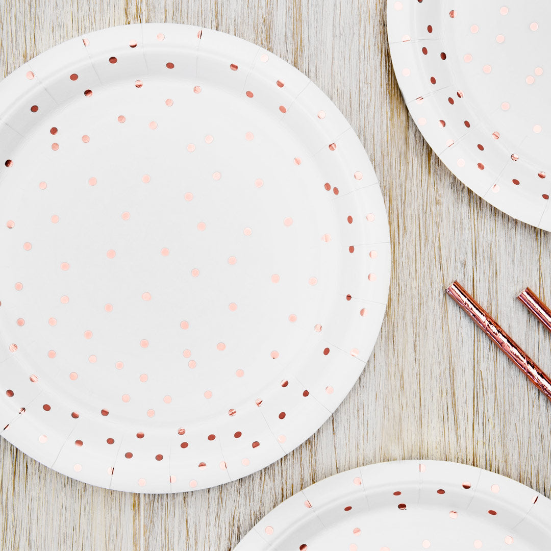 Platos de papel blancos con topos en color oro rosa. 