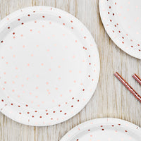 Platos de papel blancos con topos en color oro rosa. 