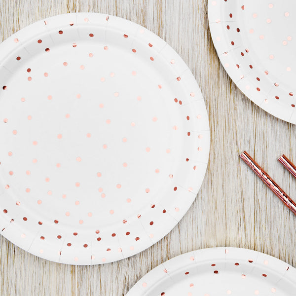 Platos de papel blancos con topos en color oro rosa. 
