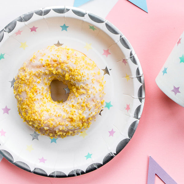 Platos de papel con diseño de estrellas en tonos rosa, lila, verde, amarillo y plata. Pack de 6 unidades, diámetro 18 cm.