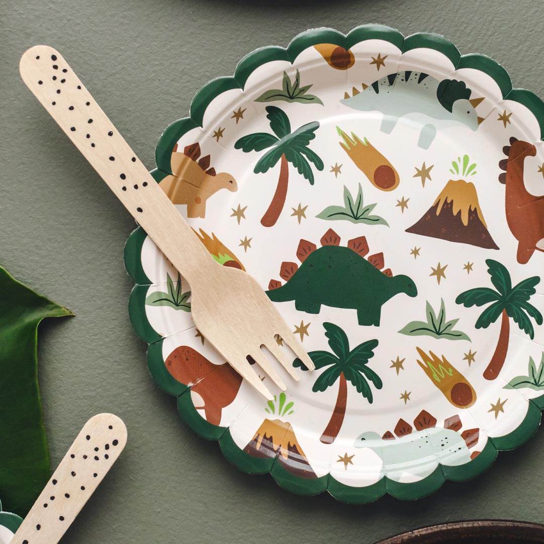 Mesa de cumpleaños temático de dinosaurios decorada con platos de papel prehistóricos