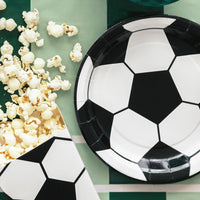 Mesa de cumpleaños infantil temático de fútbol decorada con platos de papel balón