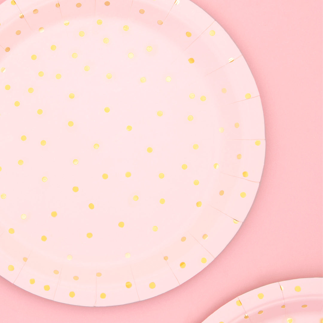 Platos de papel en color rosas con topos dorados. 