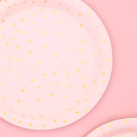 Platos de papel en color rosas con topos dorados. 