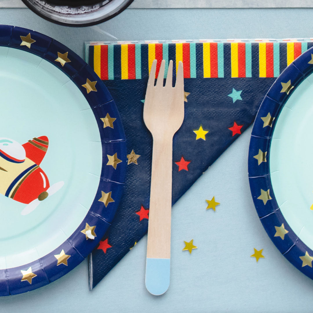 Mesa de cumpleaños festiva decorada con servilletas de papel estrellas multicolor sobre azul marino