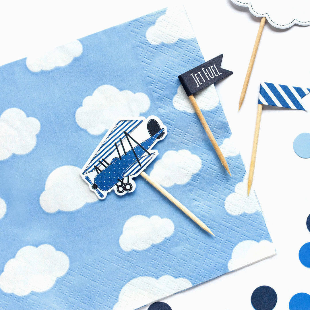 Servilletas de papel nubes azul cielo decorando fiesta temática de aviones o baby shower niño