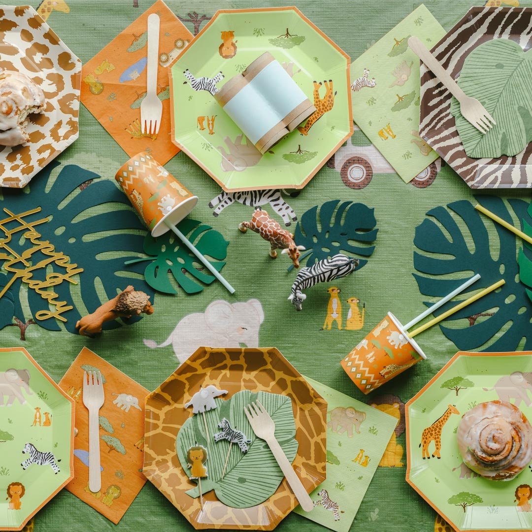 Mesa de fiesta infantil temática safari decorada con servilletas de papel verde y naranja