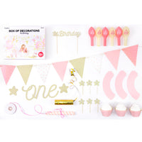 Detalle del set de decoraciones para primer cumpleaños en rosa y dorado con globos, guirnalda y toppers.