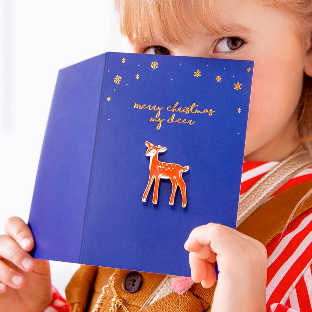 Tarjeta de Navidad azul marino con pin de ciervo y estampado dorado