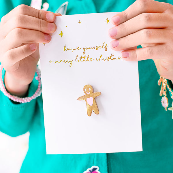 Tarjeta de Navidad blanca con pin de muñeco de jengibre dorado