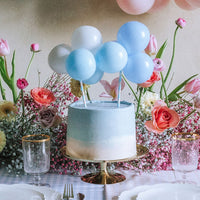 Topper de tarta de globos azul y blanco decorando tarta de baby shower
