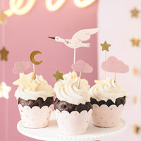 Toppers cupcakes cigüeña y nubes rosas decorando mesa de bautizo o bienvenida al bebé
