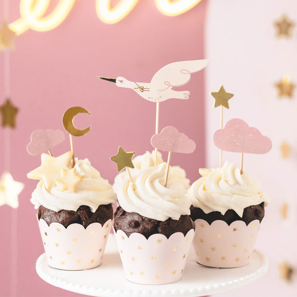 Toppers cupcakes cigüeña y nubes rosas decorando mesa de bautizo o bienvenida al bebé