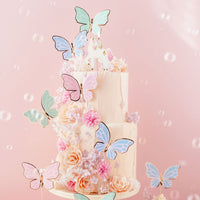Toppers mariposas pastel y dorado decorando tarta de cumpleaños con estética primaveral