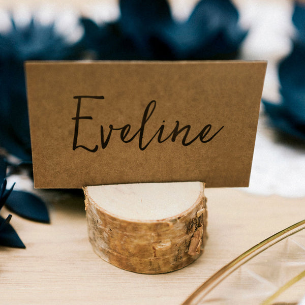 Troncos de madera porta tarjetas en mesa decorada