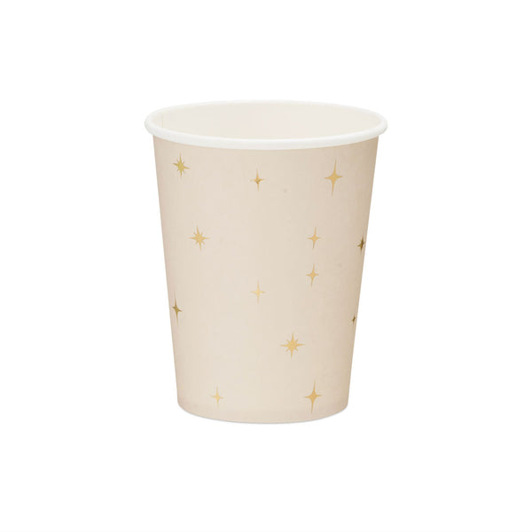 Detalle de las estrellas doradas de cuatro puntas sobre vaso de papel beige rosado