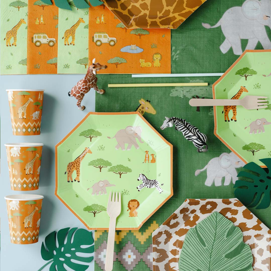 Mesa de fiesta infantil temática safari decorada con vasos de papel naranja con animales