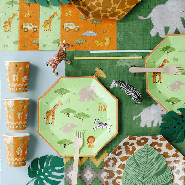 Mesa de fiesta infantil temática safari decorada con vasos de papel naranja con animales