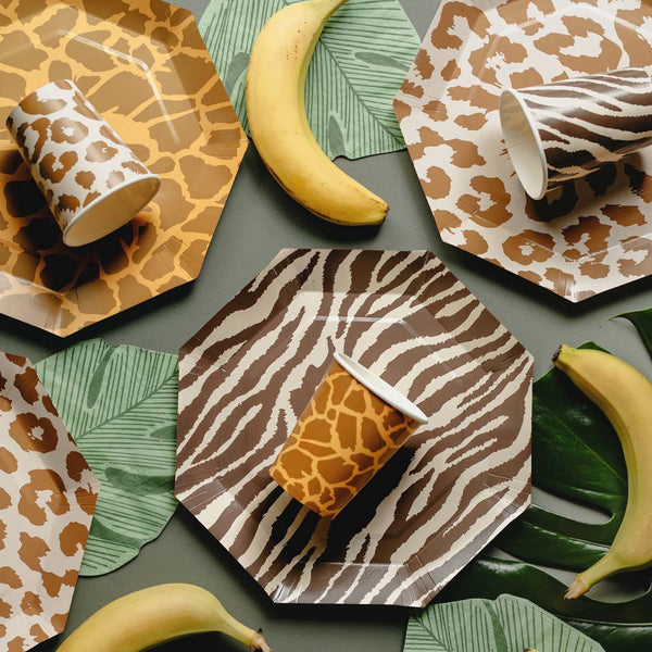 Mesa de fiesta temática safari decorada con vasos de papel con estampados de animales