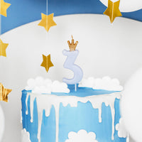 Vela de cumpleaños con número azul y corona dorada decorando tarta de cumpleaños infantil