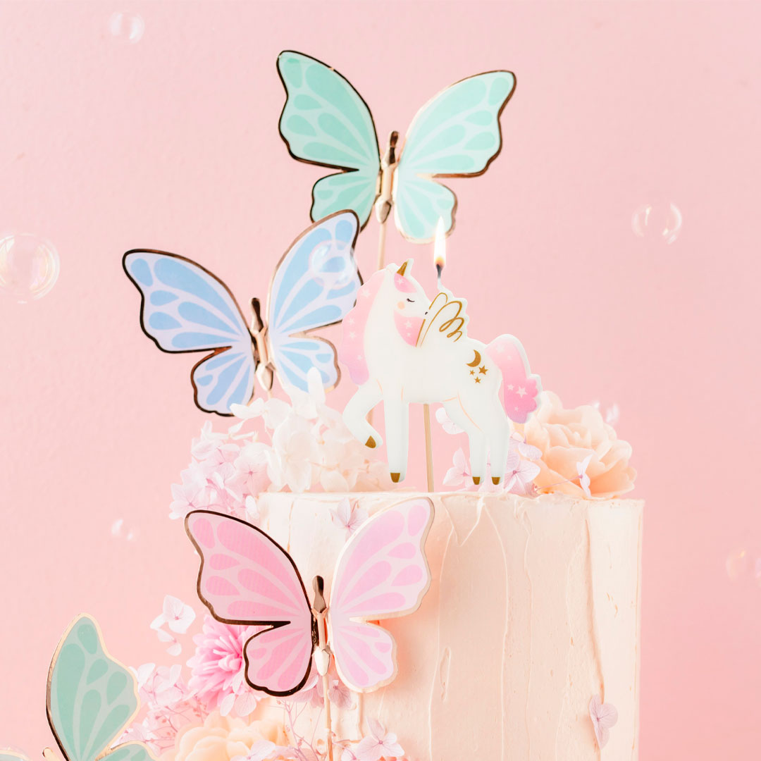 Vela de cumpleaños unicornio rosa y dorado decorando tarta de cumpleaños temática de unicornio